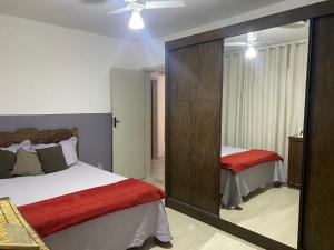 迪亚曼蒂纳Apartamento Diamante的一间卧室设有两张床和大镜子