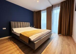 雅西Cubrio Apartments的一间卧室配有一张蓝色墙壁和木地板。