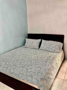 居林SUPER COMFY HOME @ KULIM CITY的卧室内的一张带两个枕头的床