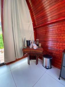 迦太基Glamping Campo Alegre的木墙客房内的小桌子