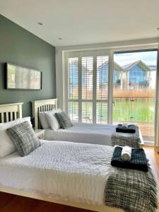 赛伦塞斯特Luxurious Lakefront Home with Pool/Spa Access的卧室设有两张床和大窗户