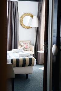 博尔斯瓦德Hotel de Wijnberg的一间卧室配有一张床、一把椅子和镜子