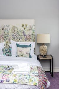 约克Plum and Partridge Husthwaite的一间卧室配有一张带花卉床头板的床