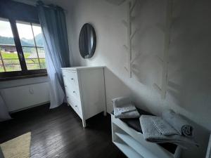 RuerasCasa Ucliva - Charming Alpine Apartment Getaway in the Heart of the Swiss Alps的白色卧室配有梳妆台和镜子