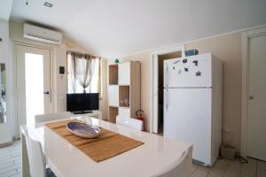 贾迪尼-纳克索斯Casa Vacanza Giugiò的厨房配有桌子和白色冰箱。