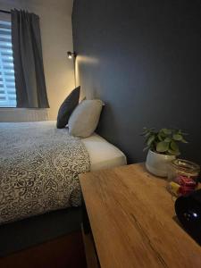 普罗丰德维耶Le Revella的一间卧室配有一张带枕头和桌子的床