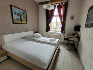 耶塞尼克Hotel Koruna的卧室配有白色的床和窗户。