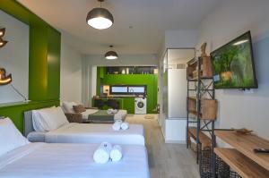 塞萨洛尼基Olea Apartments的客厅设有两张床和绿色的墙壁