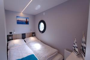温德托尔夫Hausboot Fjord Lacerta mit Dachterrasse in Wendtorf的卧室配有一张床,墙上挂着一个钟