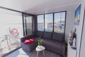 温德托尔夫Hausboot Fjord Lacerta mit Dachterrasse in Wendtorf的带沙发的客厅,享有海景