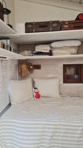拉佩德雷拉Tiny house y casa Parador de playa的卧室配有带白色枕头和行李的床