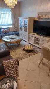 丹吉尔ESPACIOSO的客厅配有大电视和沙发