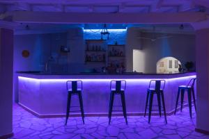 卡沃斯Euphoria complex的一间客房内的紫色吧台,配有三张酒吧凳