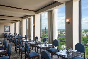 纽黑文阿米尼新港耶鲁酒店的餐厅设有桌椅和大窗户。