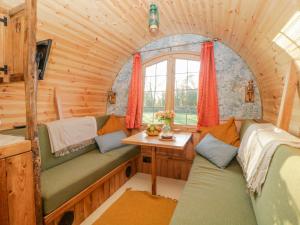 奥特里圣玛丽The Wagon at Burrow Hill的小屋内配有沙发和桌子的房间