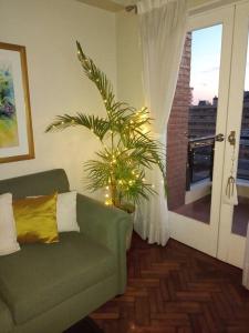 圣米格尔·德·图库玛Muy agradable departamento. Bien ubicado, luminoso的客厅配有绿色沙发和植物