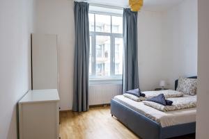 维也纳Vienna Living Apartments - Ottakring的一间卧室设有一张床和一个大窗户