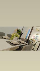 关丹Orchid Guesthouse Kuantan的一张长桌子,上面有椅子和盘子
