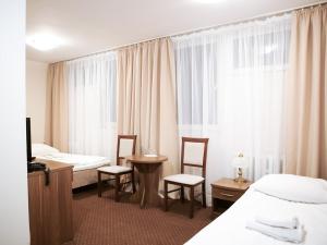 普瓦维伊莎贝拉酒店的酒店客房带两张床和一张桌子以及椅子。