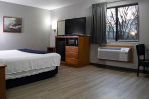 诺福克诺福克新维多利亚套房酒店 的配有一张床和一台平面电视的酒店客房
