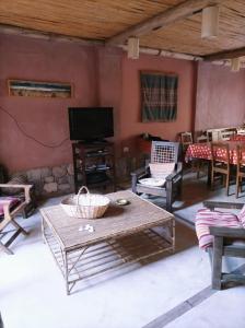 蒂尔卡拉La Elegida的客厅配有桌椅和电视。