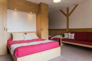 拉赫兹耶尔Chalet Matsuzaka - chambres d'hôtes de luxe的一间卧室设有一张大床和一张红色长凳