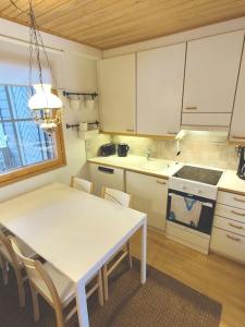 萨利色尔卡Gold Legend Paukkula #4 - Saariselkä Apartments的厨房配有桌子和白色的桌椅
