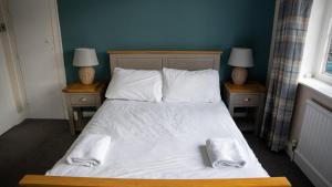 灵格弗尔德The Star Inn的一间卧室配有一张床、两个床头柜和两盏灯。