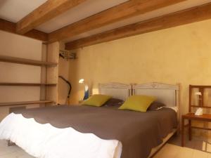 勒帕莱Maison Le Palais, 4 pièces, 6 personnes - FR-1-418-64的一间卧室配有一张带黄色枕头的大床