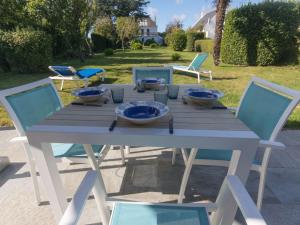 勒帕莱Maison en pierres au calme avec jardin proche plages et sentier côtier - FR-1-418-88的一张带蓝色碗和椅子的木桌