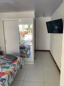 萨尔瓦多Pousada Villa Encantada LGBTQIAPlus的一间卧室配有一张床,并在一间客房内配有电视。