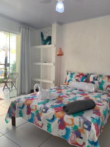 萨尔瓦多Pousada Villa Encantada LGBTQIAPlus的一间卧室配有一张带五颜六色棉被的床