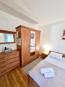 苏佩塔尔Villa Sofija的一间卧室配有两张床、一个梳妆台和镜子