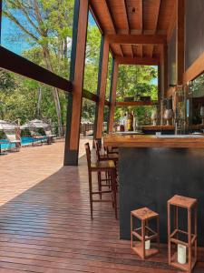 伊瓜苏港Selvaje Lodge Iguazu的甲板上的酒吧,配有桌椅