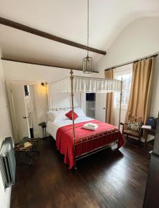 基尤Maids Guest Rooms的一间卧室配有一张带红色毯子的天蓬床