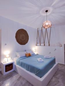 梅加斯·亚洛斯-奈特斯Litus Studios的一间卧室配有蓝色的床和吊灯。