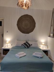 梅加斯·亚洛斯-奈特斯Litus Studios的一间卧室,在床上配有2条毛巾,床上配有吊灯