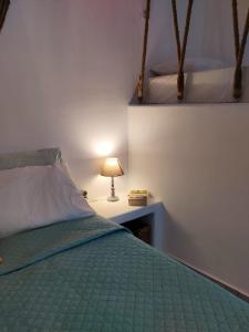 梅加斯·亚洛斯-奈特斯Litus Studios的一间卧室配有一张床和一张桌子上的台灯