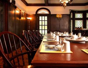圣约翰斯李塞德庄园酒店的用餐室配有长木桌子和椅子