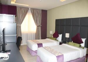 Abyār ‘Alīفندق نواة المدينة的酒店客房设有两张床和电视。