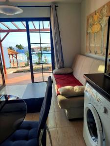 卡勒达德福斯特Sun beach Caleta 24的带沙发和洗衣机的客厅