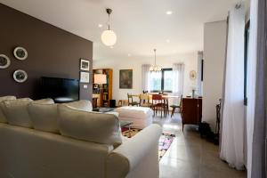 科维良Laje da Bica Agroturismo的一间带白色沙发的客厅和一间用餐室