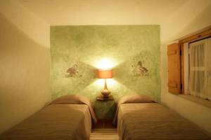 科鲁希Monte Do Areeiro的两张床位于带墙上灯的房间