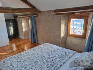 Odeillo-ViaLe Grenier des Moineaux的一间卧室设有一张床和一个窗口