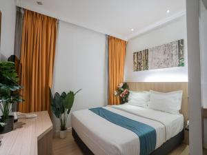 吉隆坡Floresta Hotel Chinatown的一间卧室配有大床和橙色窗帘