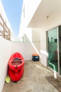 恩塞纳达港#CasaMare - Privada a una cuadra del mar con AC的坐在大楼角落的红色皮艇