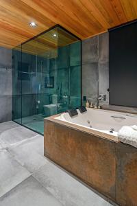 乌鲁佩马Refúgio de Altitude的带浴缸和玻璃淋浴间的浴室。
