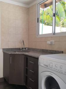 布宜诺斯艾利斯Depto para descansar y disfrutar的厨房配有洗衣机和水槽