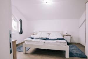 帕利克Tulip Guest House II.的卧室配有白色床和蓝色地毯