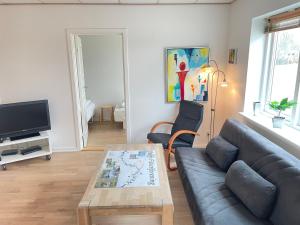 斯凯恩Skjernaa-ferie/ Andersen Invest的客厅配有沙发和桌子